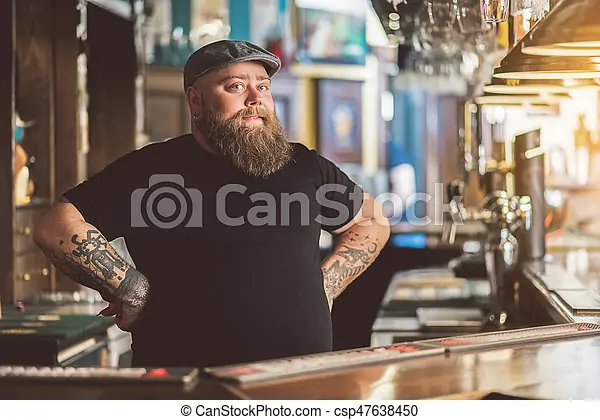 Camarero en cervecería con los brazos en jarra
